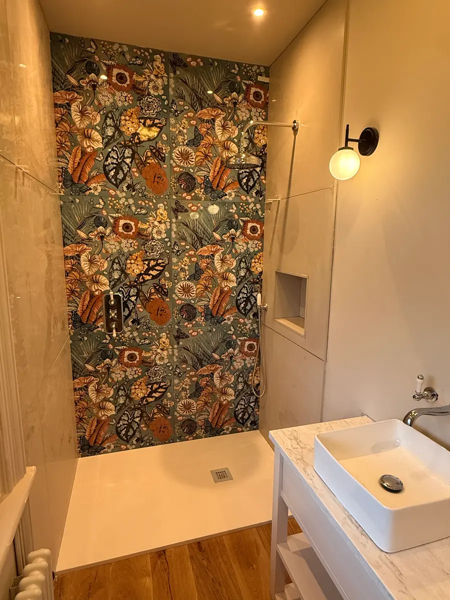 Walk-in shower with a patterned feature tile wall and a vessel basin