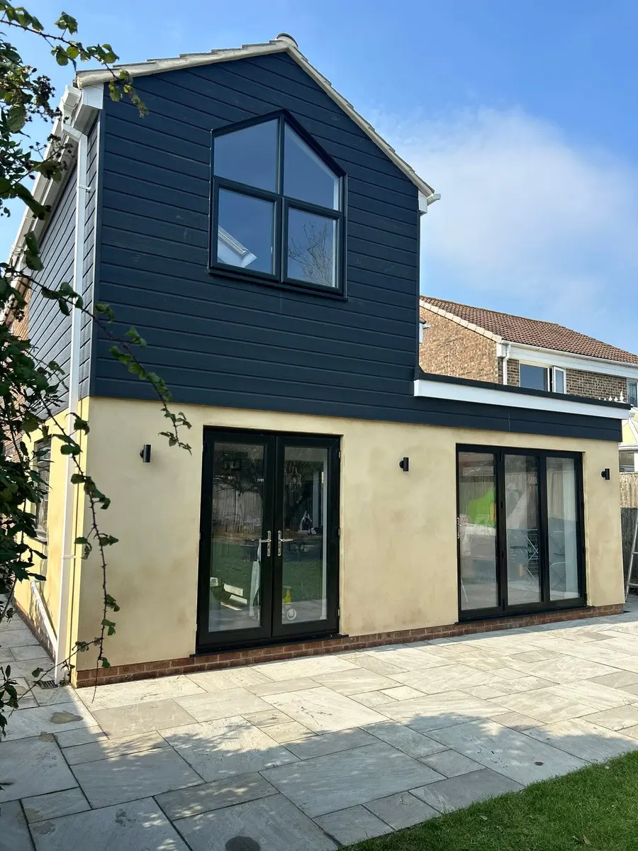 House with a dark clad dormer and gable over a new ground-floor extension
