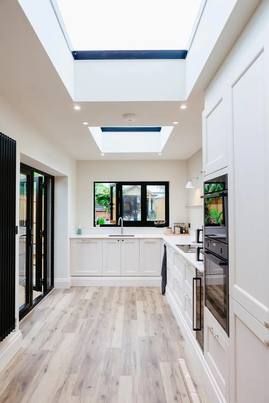 Bright kitchen extension with two roof lanterns and wood-effect flooring